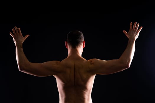 Image of muscle man posing in a studio, dark white red background