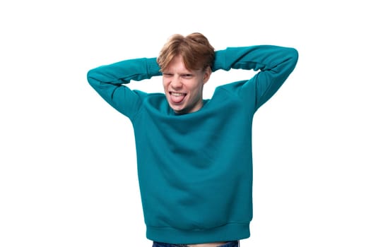 young cheerful handsome man with red hair dressed in a blue jacket on a white background with copy space.