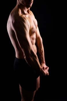 Image of muscle man posing in a studio, dark white red background