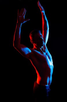 Image of muscle man posing in a studio, dark white red background