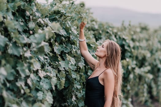 Woman at autumn winery. Portrait of happy woman holding glass of wine and enjoying in vineyard. Elegant young lady in hat toasting with wineglass smiling cheerfully enjoying her stay at vineyard