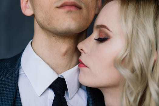 Cute wedding couple in the interior of a classic studio decorated. They kiss and hug each other.