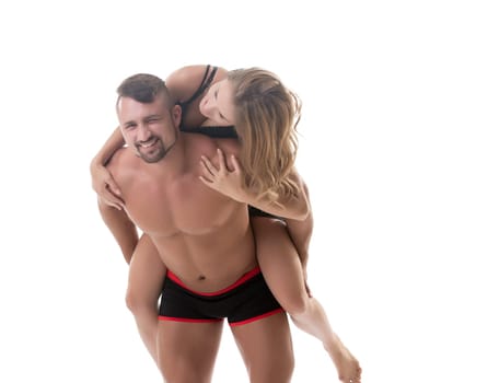 Loving athletic couple fooling around at camera. Studio photo