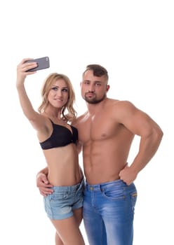 Blonde doing selfie and her boyfriend bored. Isolated over white background