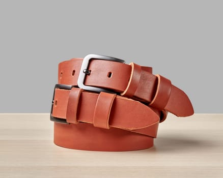 Pair of artisan terracotta leather belts with custom DAD inscription on loop, showcasing thoughtful blend of style and craftsmanship, ideal for gift for father