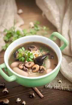 mushroom hot soup with beans in a bowl, on a rustic burlap tablecloth. AI generated image.