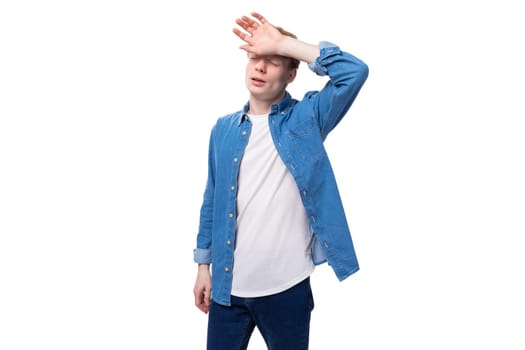 young european man with red hair wears a blue denim shirt thinks about an idea.