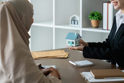 real estate agent talk about terms of home purchase agreement and ask Muslim customer to sign document to make the contract legally.