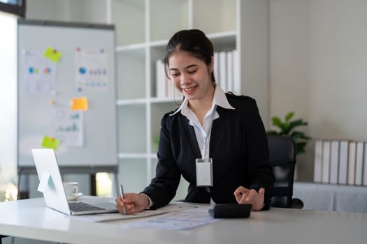 Businesswoman accountant using calculator and laptop for financial data saving in office room, Business financial, tax, accounting concept.