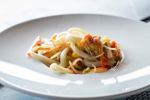 Stir-fried Yaki Udon noodles with shrimps seafood close up, vegetables and soy-based Sauce. Japanese food.