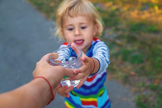 the father gives the child a glass of water. Selective focus. Kid.