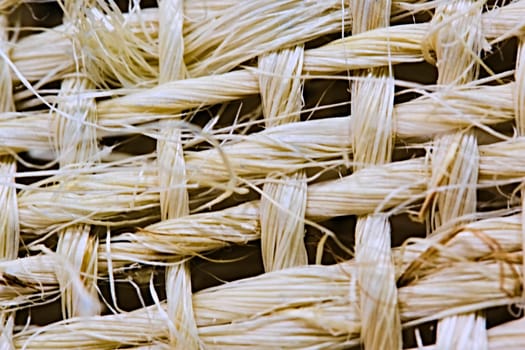 Texture of woven beige straw, background of braids from the plant stem close-up.