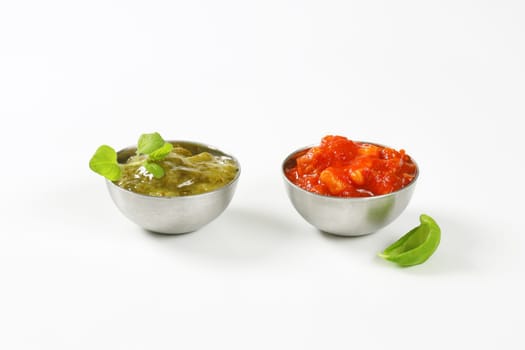 Basil pesto and tomato salsa  in metal bowls