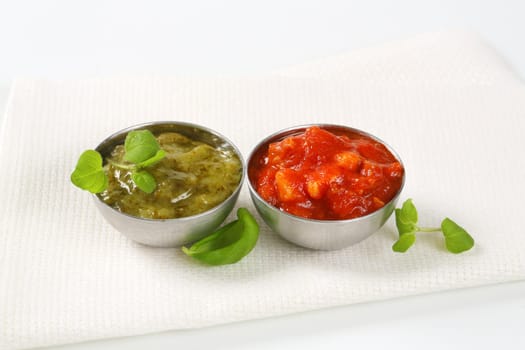 Basil pesto and tomato salsa  in metal bowls