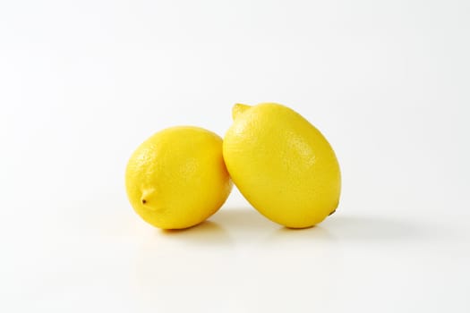 Two fresh lemon fruits on white