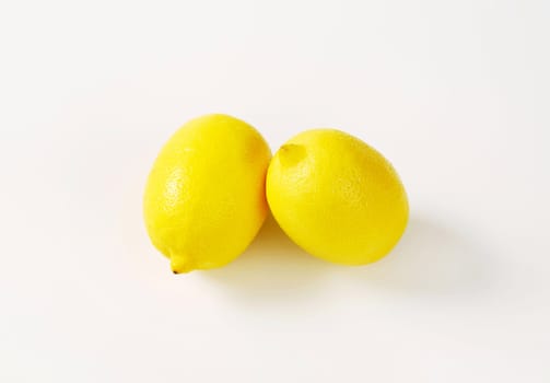 Two fresh lemon fruits on white