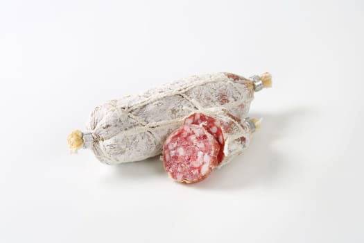 Dry cured French sausage on white background