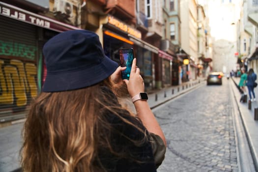 ISTANBUL, TURKEY - 08.05.2021: Young woman photographs the sights of Istanbul on her phone. High quality photo