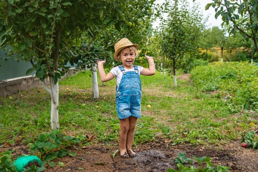 a child in the dirt in the garden holds the soil in his hands. Selective focus. Kid.