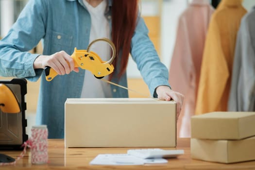 Woman packing box, package and cargo with tape for delivery, sale and shipping in workshop, startup store and creative studio.