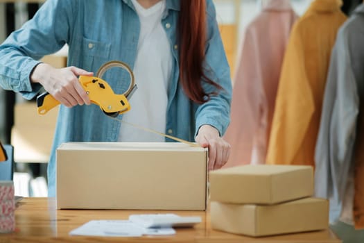 Woman packing box, package and cargo with tape for delivery, sale and shipping in workshop, startup store and creative studio.