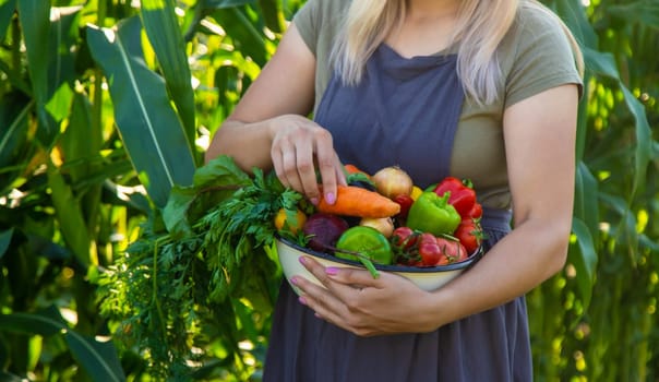 woman in the garden with vegetables in her hands.