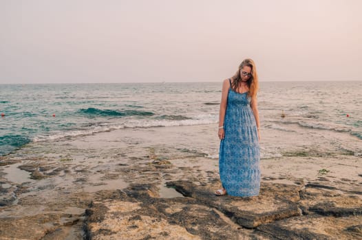 Woman sits on the beach and looks at the sea in Alanya city, Turkey. Travelling or vacation concept