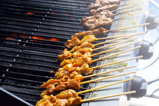 Asian cuisine, Malaysia chicken satay cooking on a hot charcoal grill. Food concept.