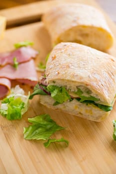 sandwich with sausage and herbs on a wooden table