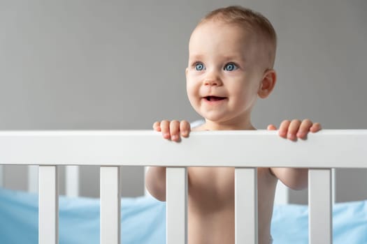 The child looks out of the crib with the hope that he will be taken away from there.