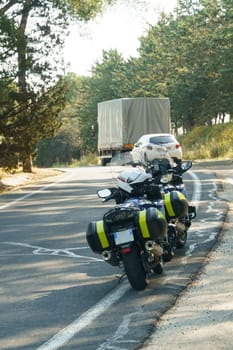 Marguerite, France - May 16, 2023: Parked along the paved road are two police motorcycles with helmets on the backs. It's a bright sunny day and a grassy embankment rises up next to parked bikes, suggesting a pause during patrol or an ongoing roadside operation.