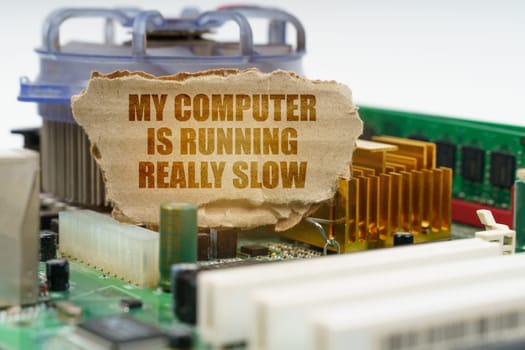 On the computer motherboard there is a cardboard with the inscription - My computer is running really slow. Computer repair concept.