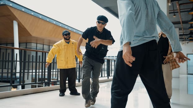 Hipster perform break dancing while partner dancing together at corridor, modern mall. Hip-hop music dancer practice footstep and move to music. Outdoor sport 2024. Active, energetic dance. Endeavor.