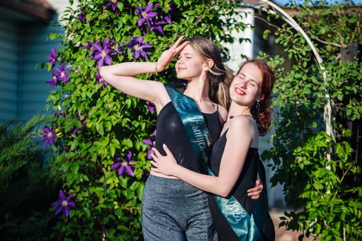 Two girls graduating posing on graduation day. Caption: Graduate 2023