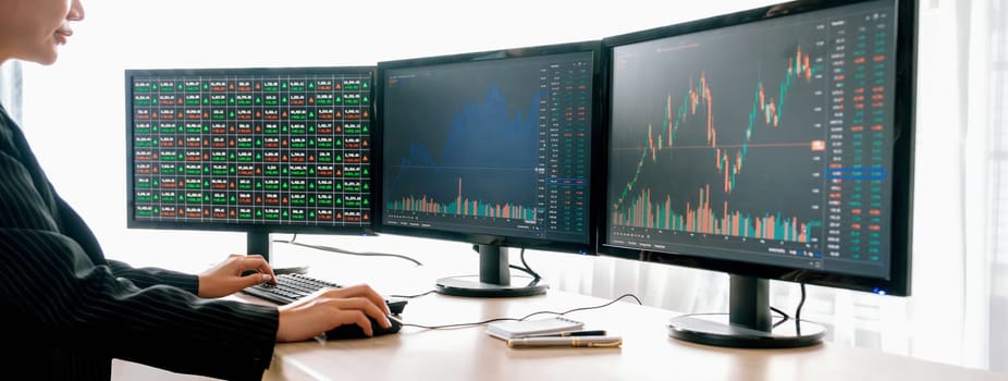 Cropped image of smart businesswoman analysis stock market data report while looking at computer screen. Young beautiful investor sitting while looking trading chart show increasing graph. Burgeoning.