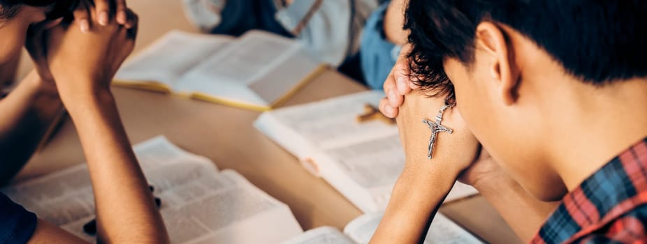 Group of christian pray to god while holding iron cross on holy bible book at church. Concept of hope, religion, faith, christianity and god blessing. Warm background Closeup. Burgeoning.