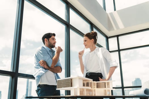 Professional architect engineer team discussing about house construction. Expert businesspeople sharing and brainstorming idea about house design. Working together. Skyscraper. Tracery.