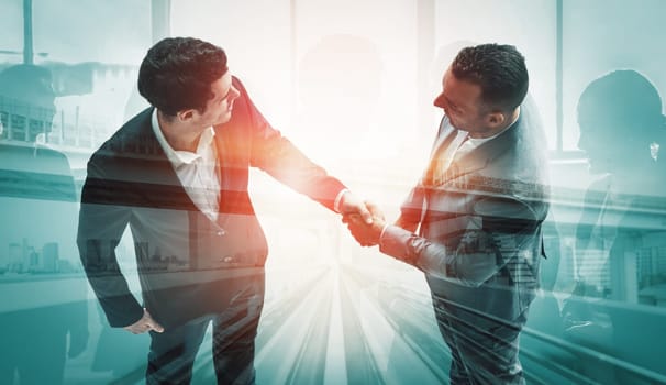 Double exposure image of business people handshake on city office building in background show partnership success of business deal. Concept of corporate teamwork, trust partner and work agreement. uds