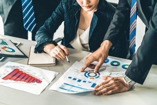 Businessman and businesswoman in meeting working with many financial statement document on desk. Concept of busy business profit analysis and brainstorm. Close up shot at people hands and papers. uds