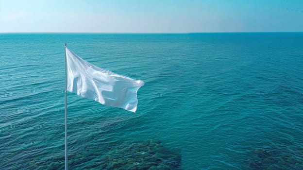 A white flag flying in the wind over a body of water