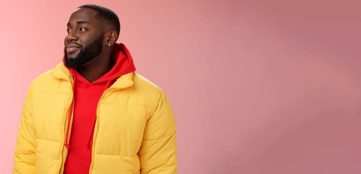 Dreamy happy optimistic black bearded man looking left daydreaming recalling nice moments, enjoying warm peaceful weather walking park feel calm relieved, standing pink background smiling cute.