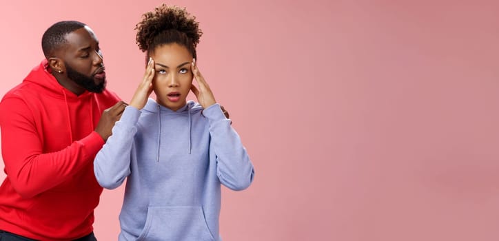 Man apologizing girlfriend behind back touching shoulder comforting girl feel pressured irritated fed up lying hear boyfriend sorry arguing standing bothered pink background, couple fighting.