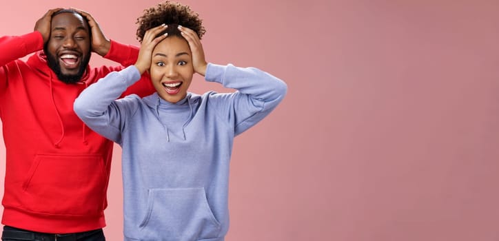 Lifestyle. Waist-up happy charming surprised couple african american girlfriend boyfriend winning awesome gift lottery smiling impressed did not except win cannot believe luck grinning holding head shocked.