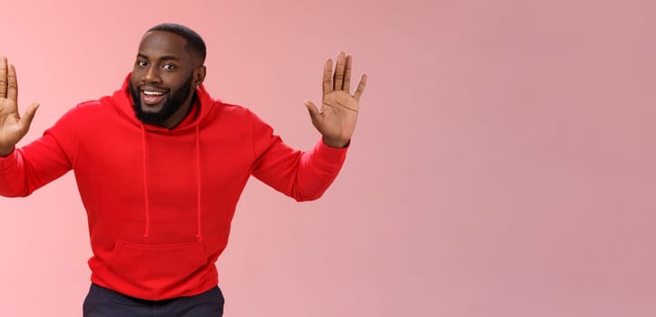 Happy charming outgoing african american male model raise hands joking standing surrender smiling give up girlfriend won grinning agree go dinner restaurant, standing pink background.