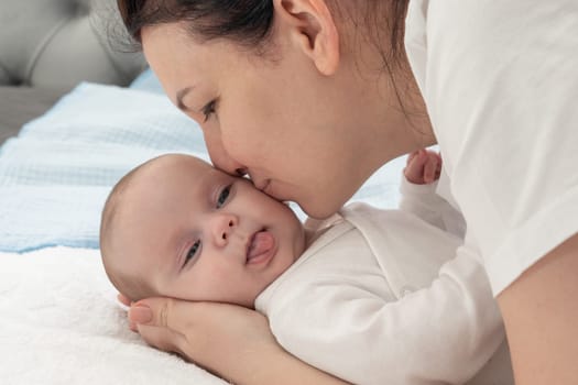 mother hugs her newborn and cuddles her cheek.