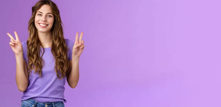 Peace friends. Relaxed friendly cute self-assured girl long curly hairstyle show victory sign smiling broadly cheering express positive optimistic attitude have fun enjoy summer purple background.