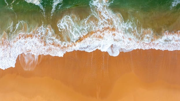 Top view of waves crushing on sandy beach. Atlantic ocean beach aerial view