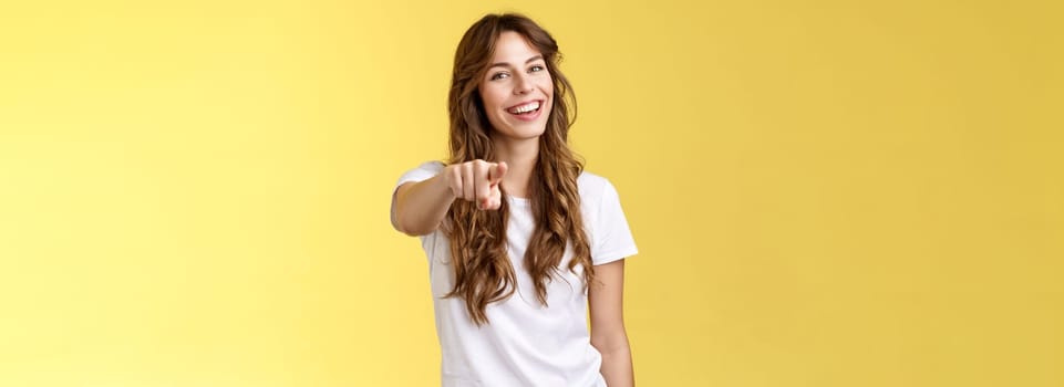 Hey you congrats. Joyful good-looking friendly enthusiastic lovely girl laughing happily pointing camera joking picking making choice congratulate excellent job stand yellow background smiling.