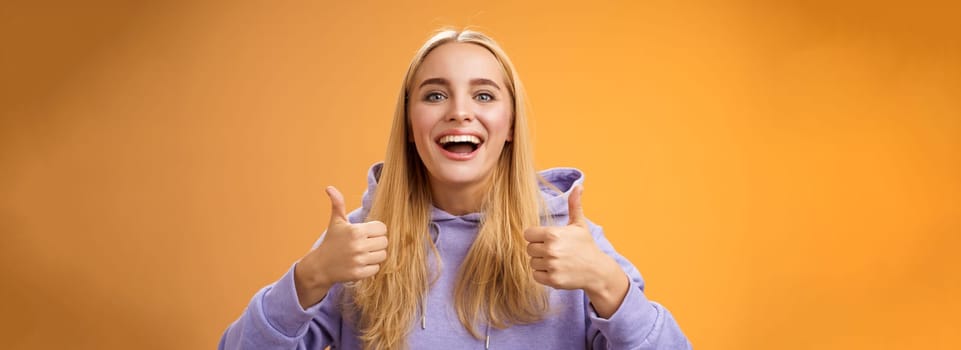 Supportive cute blond girlfriend cheering liking interesting concept cool idea thumbs-up smiling broadly agree approve outfit shopping together friends, recommend adore new look, orange background.