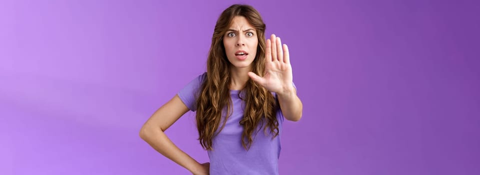 Serious-looking displeased assertive female friend stand confident demand stop smoking pull palm camera forbid disapproval gesture restrain you making bad choice purple background.